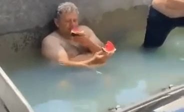 İznik'te sıcaktan bunalan inşaat işçileri, kepçenin küreğini havuza çevirdi. Suyun