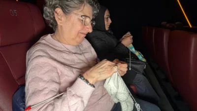 Düzce’de bir araya gelen kadınlar, sinema salonunda film izlerken ördükleri